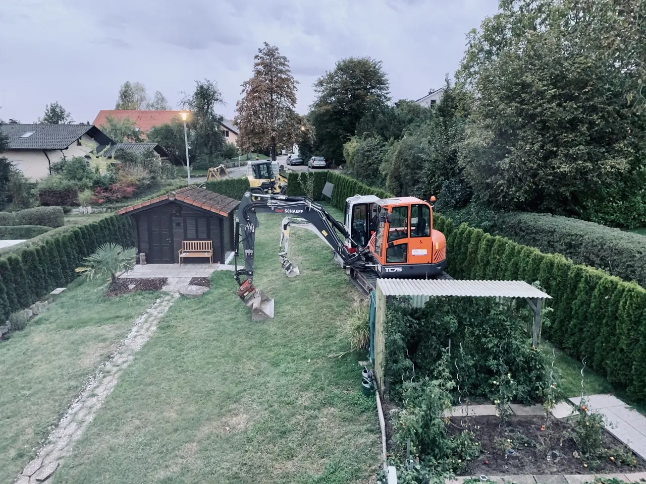 Bagger stehen zu Beginn des Gartenumbaus auf der bisherigen Rasenfläche