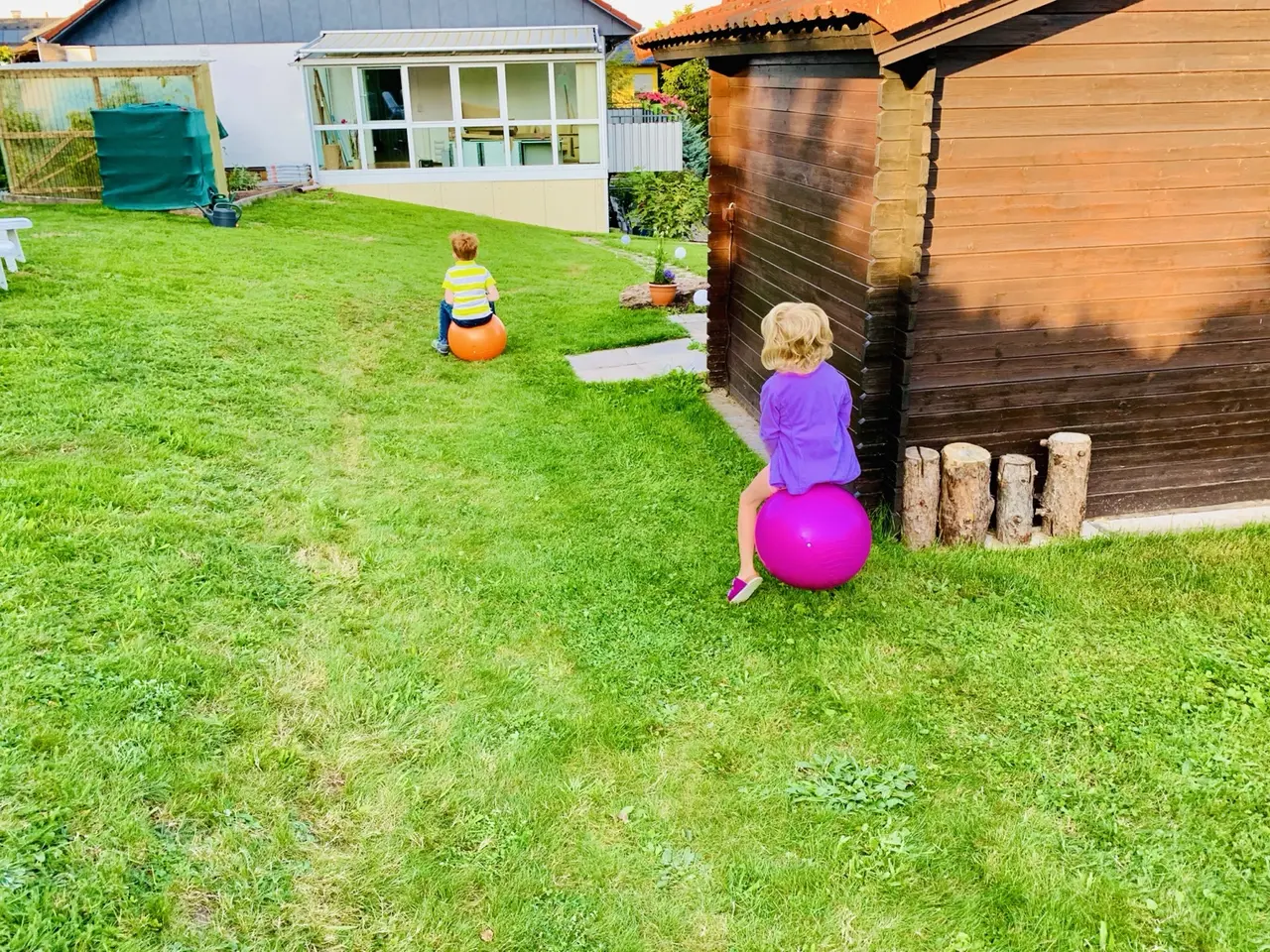Kinder spielen im früheren Garten vor dem Gartenhaus