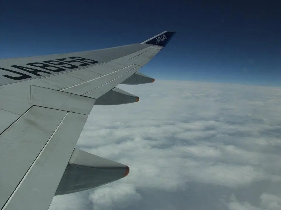 Blick über eine Flugzeugtragfläche während des Flugs nach Japan
