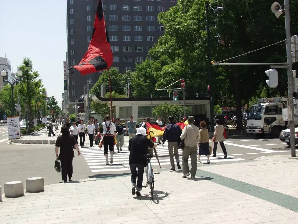 Deutsche Fußballfans mit Fahnen in einer japanischen Stadt