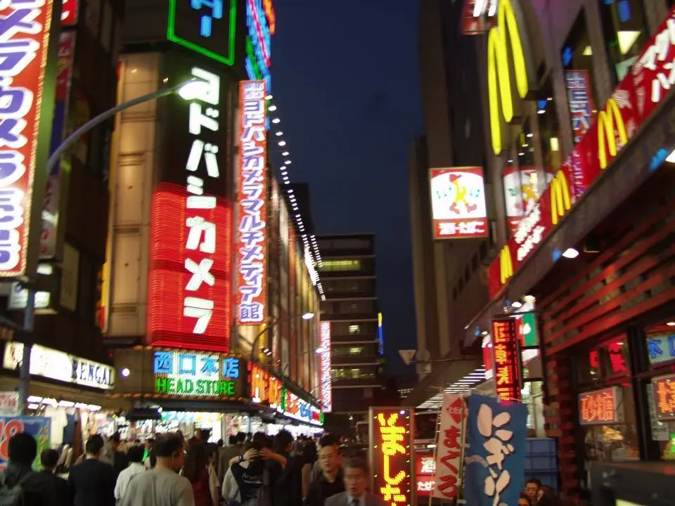 Belebte Straße mit leuchtenden Reklametafeln in Tokio bei Nacht