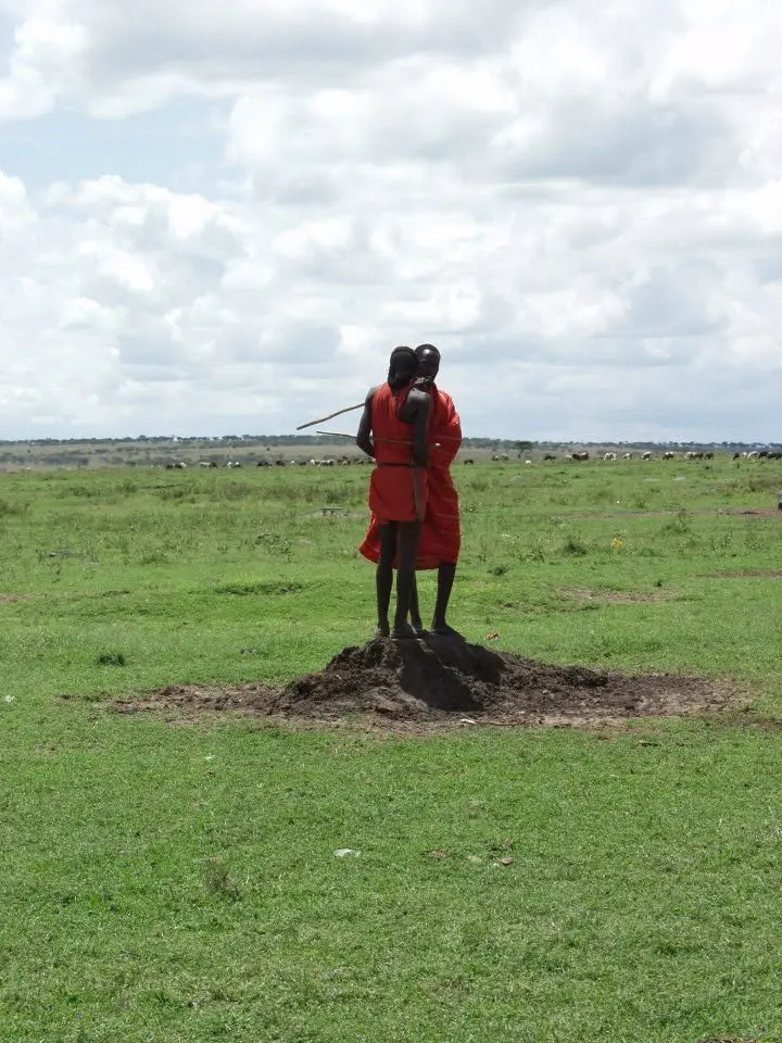 Zwei Menschen in roter traditioneller Kleidung in der weiten Landschaft Kenias